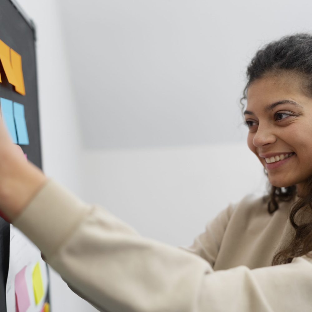 medium-shot-smiley-woman-sticking-post-it-board